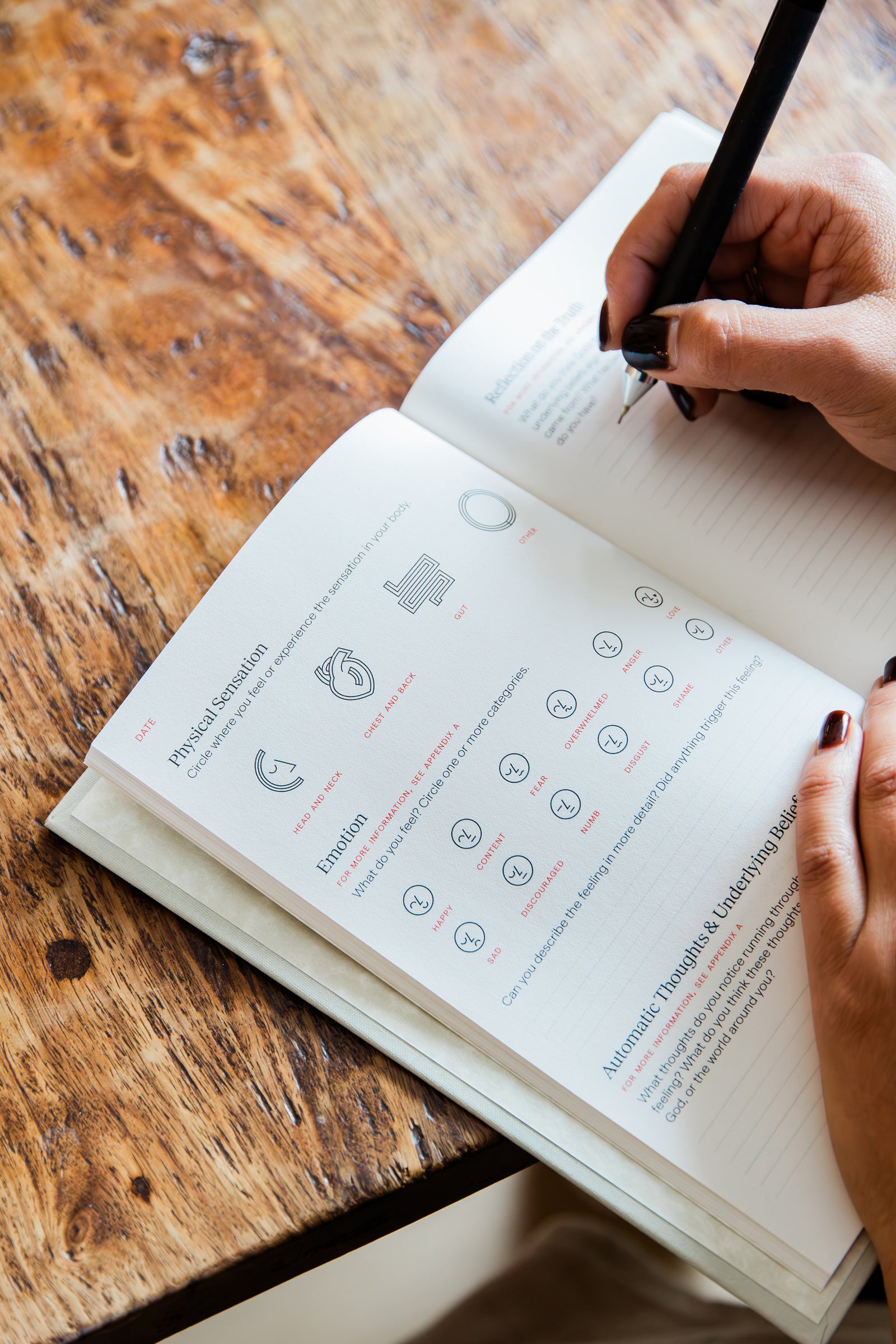 Writing in the Overcomers Journal's guided daily page for identifying emotions