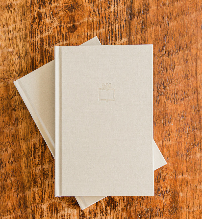 The Overcomers Journal, a linen hardcover Christian journal, on a wood table